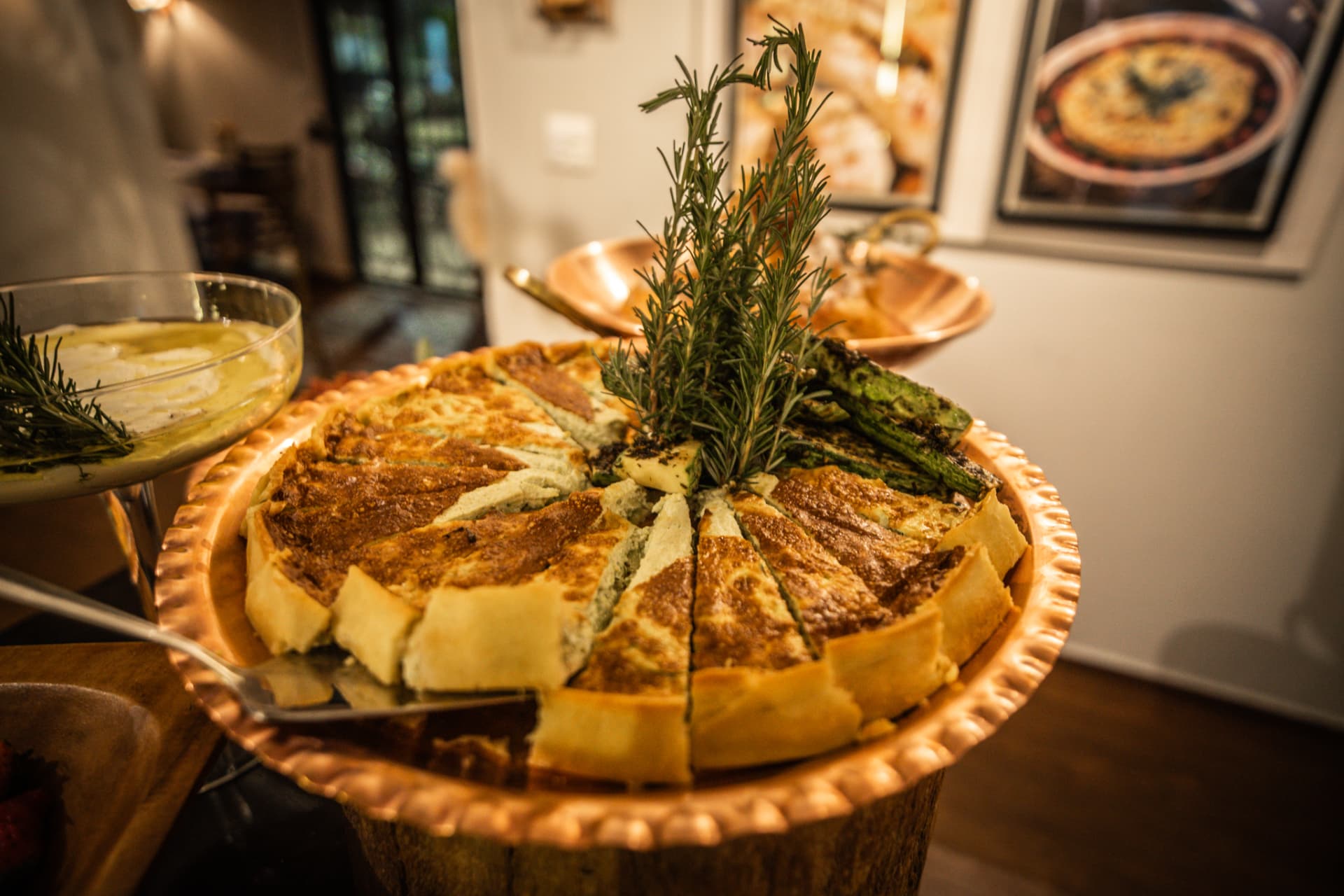 Torta de ervas fatiada em travessa de cobre
