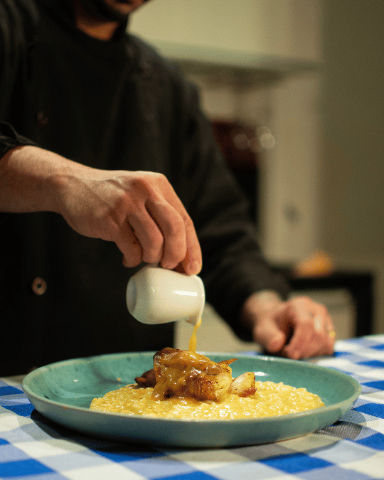 Chef servindo molho sobre prato da casa