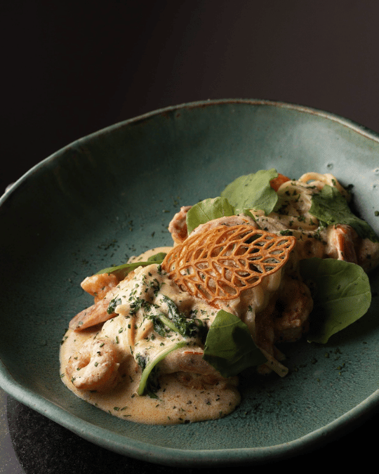 Camarões ao creme com rúcula e crocante de parmesão